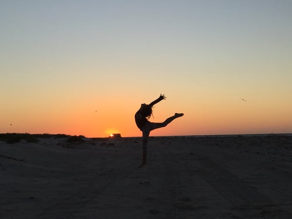 femme sur une plage au coucher du soleil